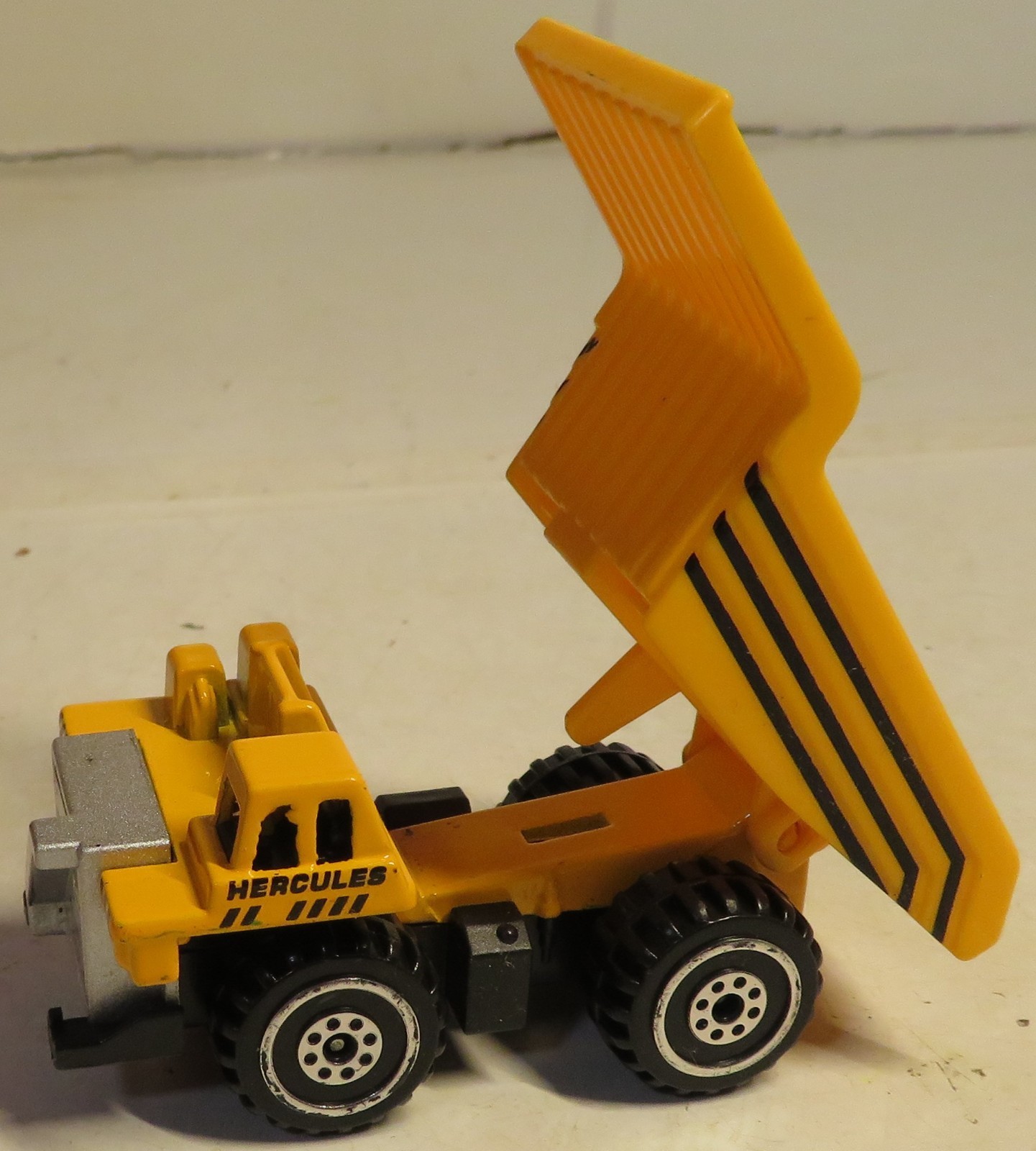 Hercules Classic Construction Toy 3″ Long Dump Truck Yellow Plastic Grading Haul