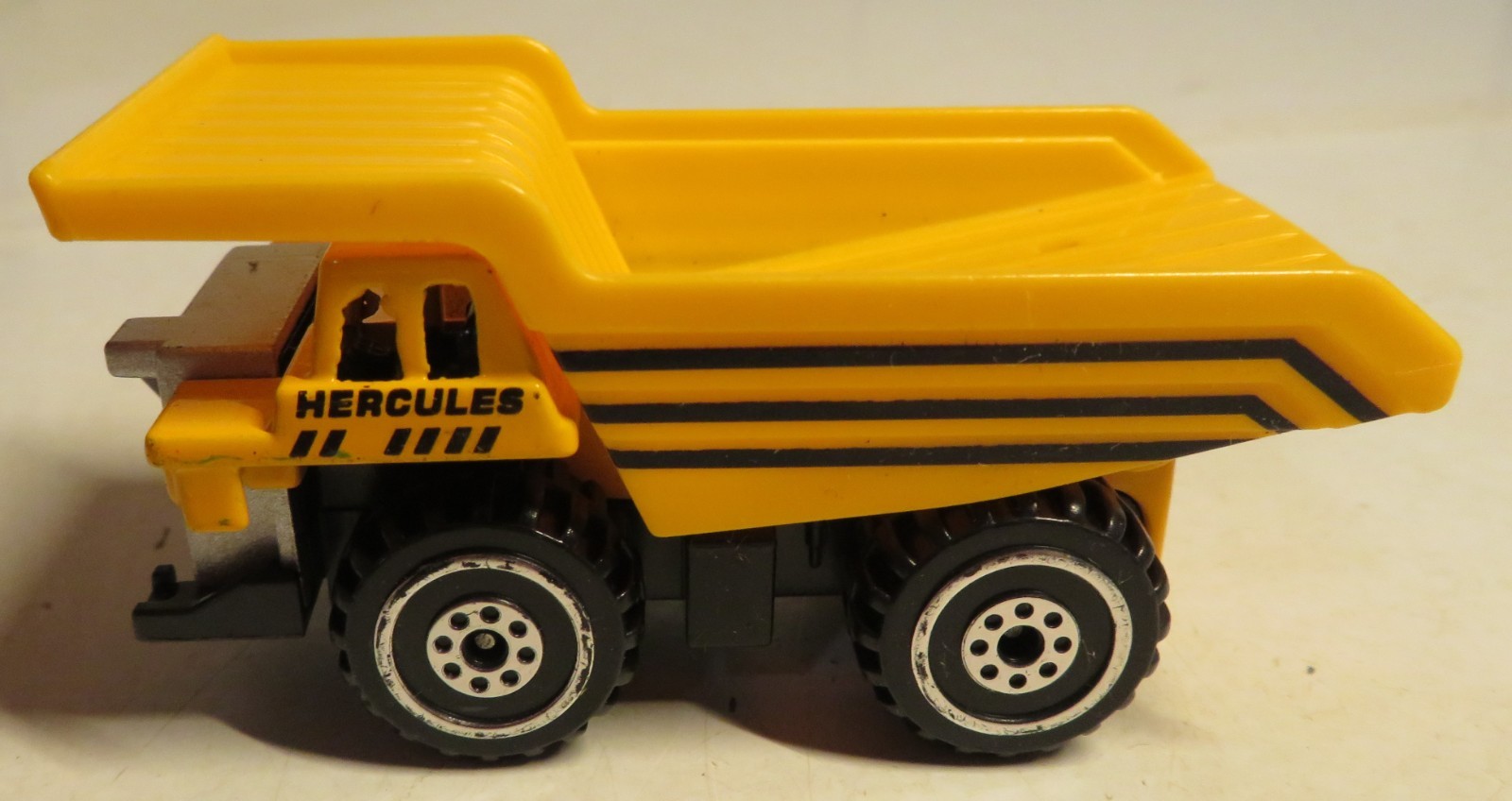 Hercules Classic Construction Toy 3″ Long Dump Truck Yellow Plastic Grading Haul