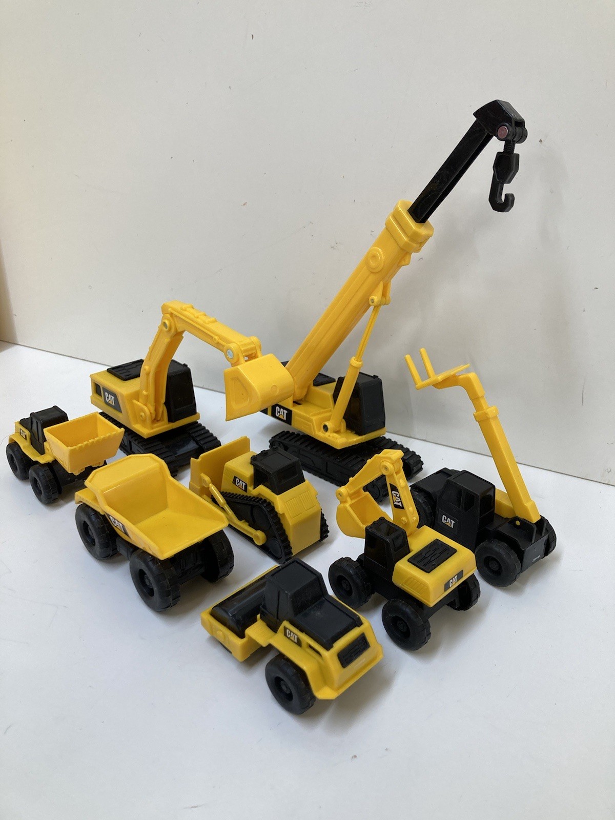 8 Small 3”-4” Long Plastic Toy Caterpillar Construction Trucks. Movable Parts
